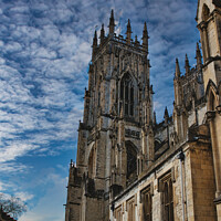 Buy canvas prints of Gothic cathedral against a dramatic sky with fluffy clouds, showcasing intricate architecture and historical grandeur, ideal for travel and cultural themes in York, North Yorkshire, England. by Man And Life