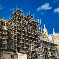 Buy canvas prints of Historic cathedral undergoing renovation, with intricate scaffolding against a bright blue sky with clouds. Architectural preservation concept in York, North Yorkshire, England. by Man And Life