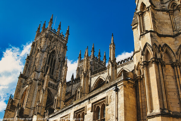 Majestic Gothic cathedral against a blue sky with clouds, showcasing intricate architecture and historical religious significance in York, North Yorkshire, England. Picture Board by Man And Life