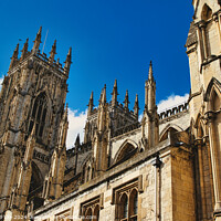 Buy canvas prints of Majestic Gothic cathedral against a blue sky with clouds, showcasing intricate architecture and historical religious significance in York, North Yorkshire, England. by Man And Life