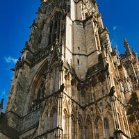 Buy canvas prints of Gothic cathedral facade with intricate architecture against a clear blue sky, showcasing historical religious building's exterior details in York, North Yorkshire, England. by Man And Life