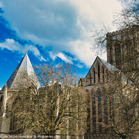 Buy canvas prints of Historic medieval cathedral with Gothic architecture, featuring pointed arches and robust stone walls, set against a vibrant blue sky with fluffy clouds in York, North Yorkshire, England. by Man And Life