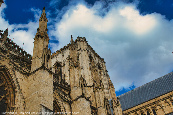 Majestic gothic cathedral facade against a dramatic sky with fluffy clouds, showcasing intricate architectural details and historical religious significance in York, North Yorkshire, England. Picture Board by Man And Life