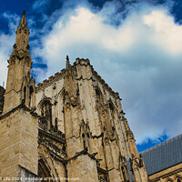 Buy canvas prints of Majestic gothic cathedral facade against a dramatic sky with fluffy clouds, showcasing intricate architectural details and historical religious significance in York, North Yorkshire, England. by Man And Life