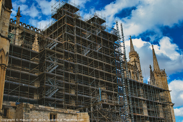 Gothic cathedral undergoing restoration, with extensive scaffolding against a dramatic cloudy sky in York, North Yorkshire, England. Picture Board by Man And Life