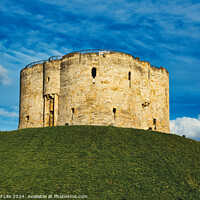 Buy canvas prints of Medieval stone tower atop a lush green hill against a vibrant blue sky with fluffy clouds, symbolizing historical fortification and ancient architecture in York, North Yorkshire, England. by Man And Life