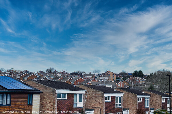 Suburban skyline with rows of houses and solar panels on a roof under a blue sky with wispy clouds in Harrogate, North Yorkshire. Picture Board by Man And Life