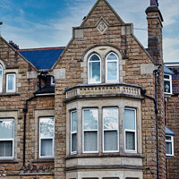Buy canvas prints of Victorian-style stone building with a gabled roof and bay windows under a blue sky with clouds, showcasing classic architectural details and craftsmanship in Harrogate, North Yorkshire. by Man And Life