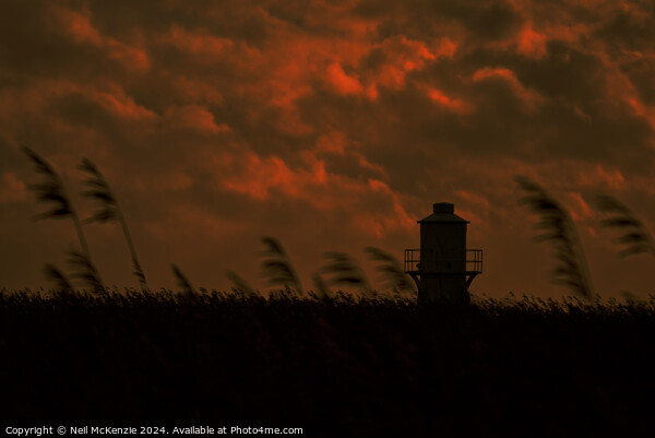 Lighthouse under a cloudy sky  Picture Board by Neil McKenzie
