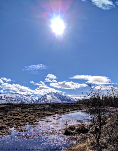 Sun shining on an icy pond and snowy mountains  Picture Board by Robert Galvin-Oliphant