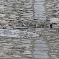 Buy canvas prints of Paving of river rock and manhole covers cast iron by Adrian Bud