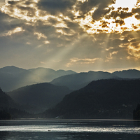 Buy canvas prints of Angel rays over Lake Bled by Ian Middleton