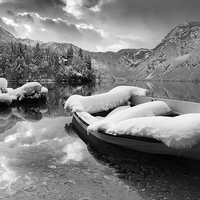 Buy canvas prints of Snow covered boat on Lake Bohinj in Winter by Ian Middleton