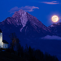Buy canvas prints of Full moon rising over Jamnik church and Storzic at by Ian Middleton