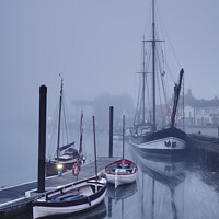 Buy canvas prints of Boats moored in the harbour in fog at dawn. Wells-next-the-sea, by Liam Grant