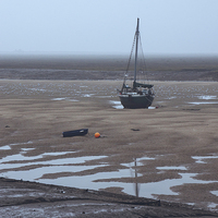 Buy canvas prints of Boat at low tide on a foggy evening. Wells-next-th by Liam Grant