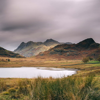 Buy canvas prints of Clouds over Blea Tarn with Langdale Pikes beyond. by Liam Grant
