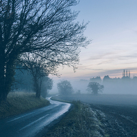 Buy canvas prints of Evening sky over rural road leading into fog. by Liam Grant