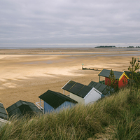 Buy canvas prints of Beach huts and sunlit view out to sea. by Liam Grant