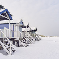 Buy canvas prints of Beach huts covered in snow at low tide. Wells-next by Liam Grant