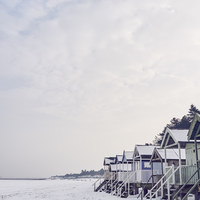 Buy canvas prints of Beach huts covered in snow at low tide. Wells-next by Liam Grant