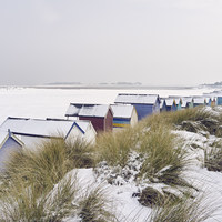 Buy canvas prints of Beach huts and dunes covered in snow at low tide.  by Liam Grant