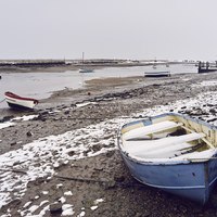 Buy canvas prints of Boats and snow at low tide. Burnham Overy Staithe, by Liam Grant