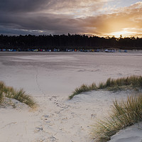 Buy canvas prints of Sunset, beach huts and footprints in the sand. Nor by Liam Grant