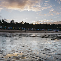 Buy canvas prints of Sunset sky and beach huts reflected in a water at  by Liam Grant