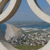 Buy canvas prints of Chesil Beach Through Olympic Rings by Nicola Clark