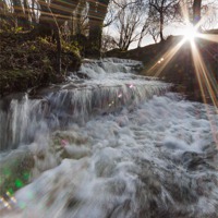Buy canvas prints of LENS FLARE with gushing stream, winter by Izzy Standbridge