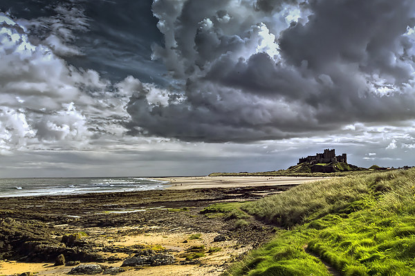 Dramatic skys over Bamburgh Castle and beach Picture Board by Kevin Tate