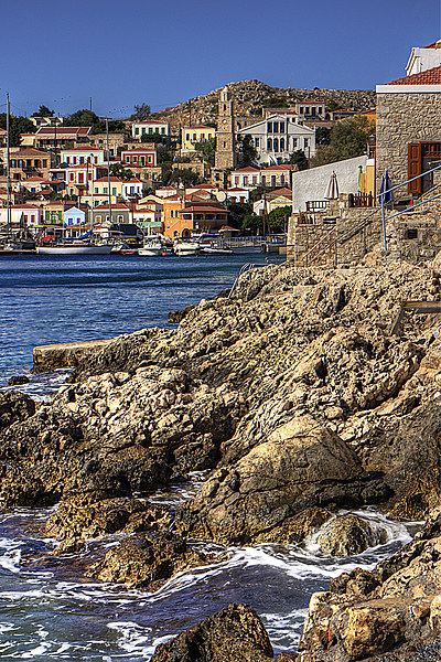 The rocky shore at Nimborio Picture Board by Tom Gomez