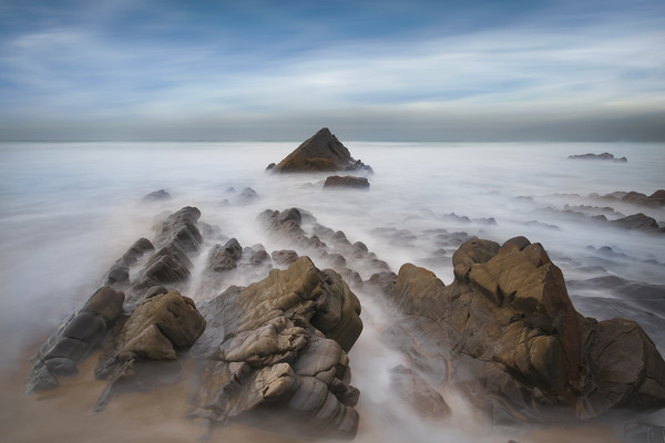 jagged rocks and smooth sea's at Sandymouth beach Picture Board by Eddie John