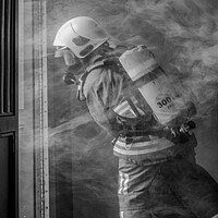 Buy canvas prints of Firefighter Working in Smoke by Roger Green