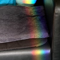 Buy canvas prints of Prisms of rainbow colours over chair & cushion by DEE- Diana Cosford