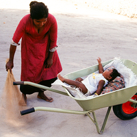 Buy canvas prints of  Mother keeps child in a wheel burrow while cleani by Hassan Najmy