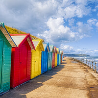 Buy canvas prints of Vibrant Beach Huts Adorning Whitby Beachfront by Derek Beattie