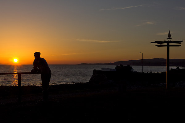 Man Statue Port William at Sunset  Picture Board by Derek Beattie