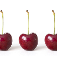 Buy canvas prints of Three Red Cherries against a White Background by Natalie Kinnear