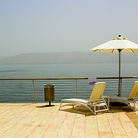 Buy canvas prints of Sun beds and Brolly on the shores of Galilee by Michael Harper