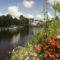 Buy canvas prints of A flower display on the riverbank, Pontivy, France by Simon Armstrong