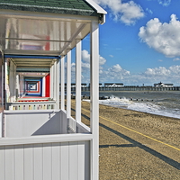 Buy canvas prints of Southwold Pier Through Beach Huts by Bill Simpson