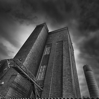 Buy canvas prints of Ominous brick tower & chimney against stormy sky by Mark Stone