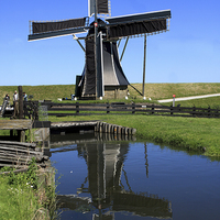 Buy canvas prints of  Windmill Reflection In A Pond  by Aidan Moran