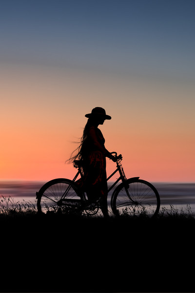Silhouette Of Girl And Bike At Sunset Near The Sea Framed Mounted Print by Maggie McCall
