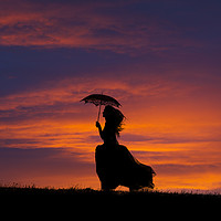 Buy canvas prints of Silhouette of young woman running at sunset by Maggie McCall