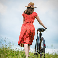 Buy canvas prints of Women pushing vintage bicycle in a field. by Maggie McCall