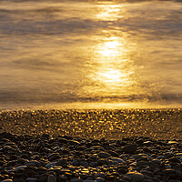 Buy canvas prints of Golden sunlight on sea and pebble beach by Phil Crean