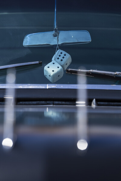Fluffy dice hang from rear view mirror Picture Board by Phil Crean